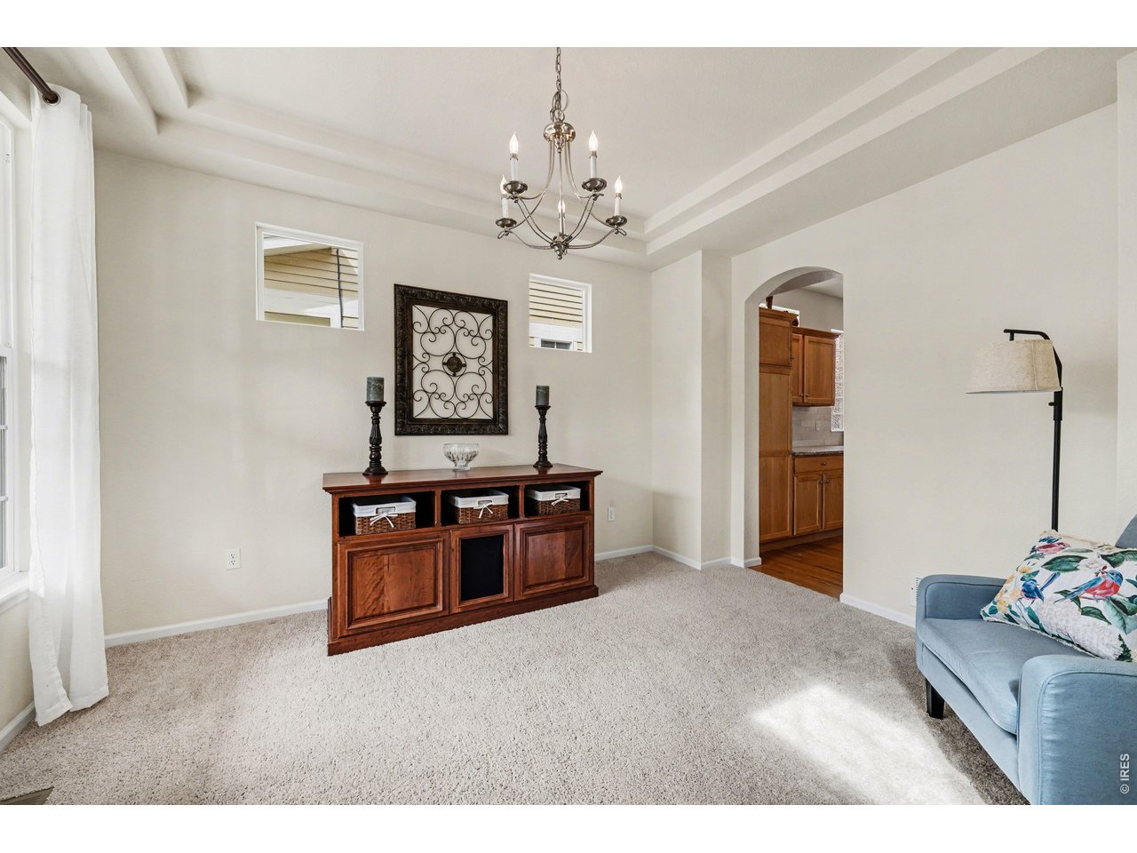 Living/Dining room featuring tray ceilings and abundant light
