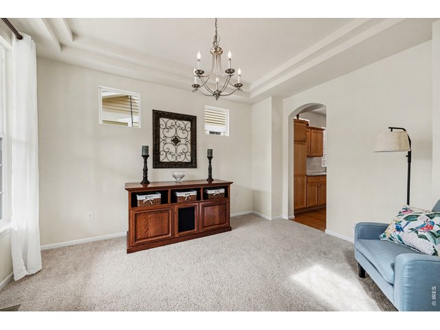 Property Photo 5 Living/Dining room featuring tray ceilings and abundant light
