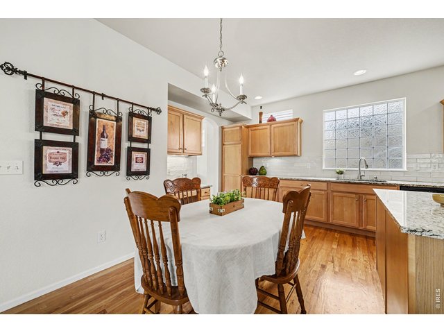 Property Photo 9 Bright eat-in kitchen featuring hardwood floors and warm wood cabinetry