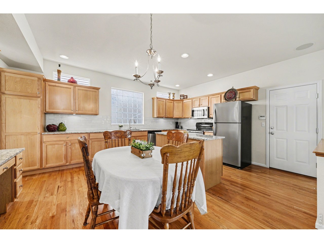 Expansive kitchen with granite counters, stainless appliances, and hardwood floors
