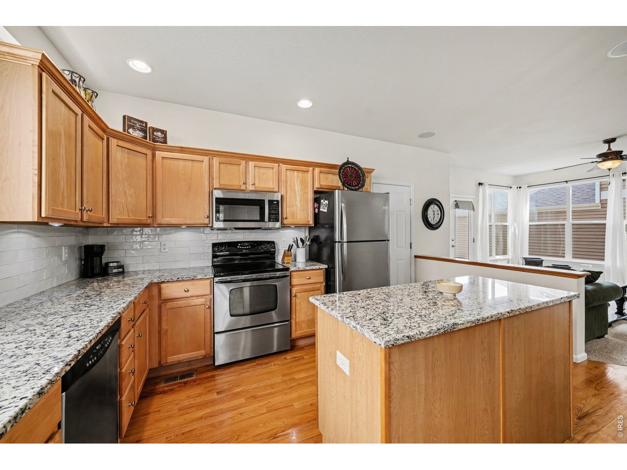 Modern kitchen featuring granite countertops, stainless steel appliances, and island