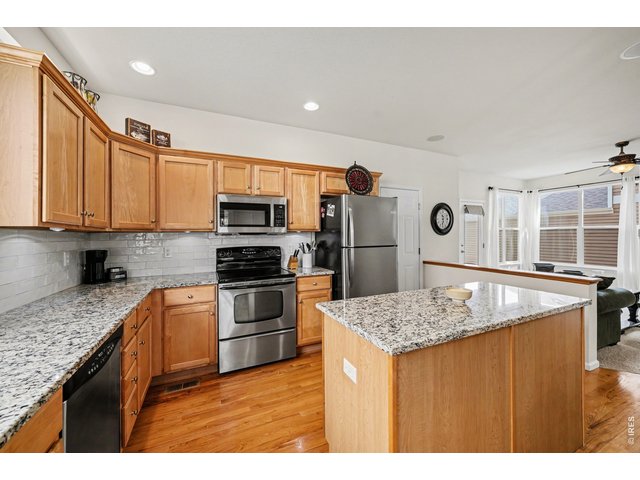 Property Photo 14 Modern kitchen featuring granite countertops, stainless steel appliances, and island