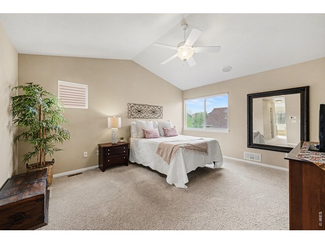 Property Photo 21 Expansive primary suite boasting vaulted ceilings, a cooling ceiling fan, and a neutral color palette that invites relaxation