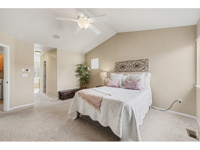 Property Photo 23 Serene primary bedroom with an open layout, featuring plush carpeting and a seamless transition to the ensuite bath
