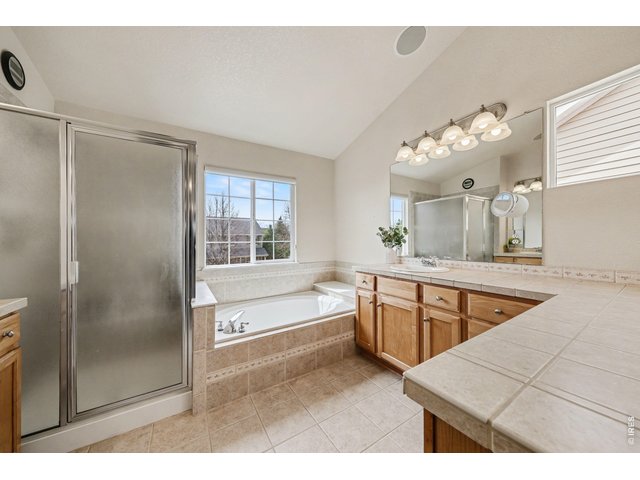 Property Photo 25 Relaxing primary bathroom showcasing a large soaking tub and a dedicated walk-in shower for a true retreat experience