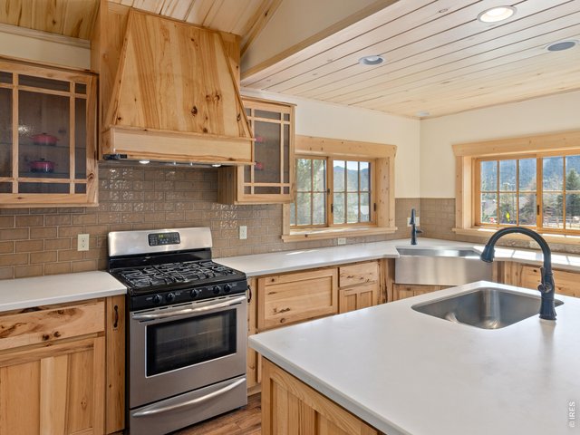 Property Photo 9 light-filled kitchen with stainless steel appliances and gas stove/oven
