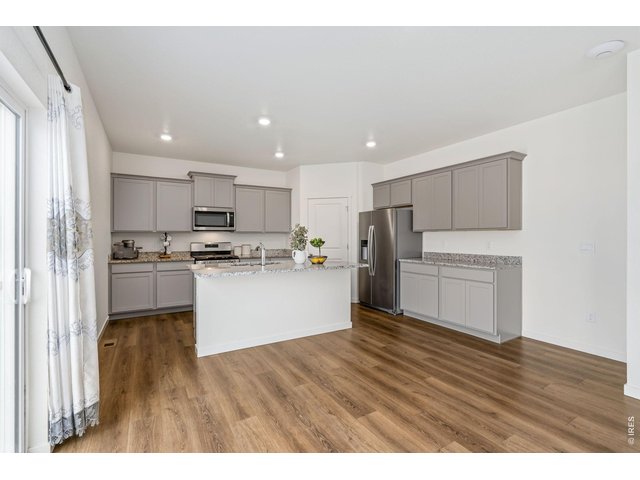 Property Photo 7 Durable wood laminate flooring extends throughout the main level, offering both style and easy maintenance. 