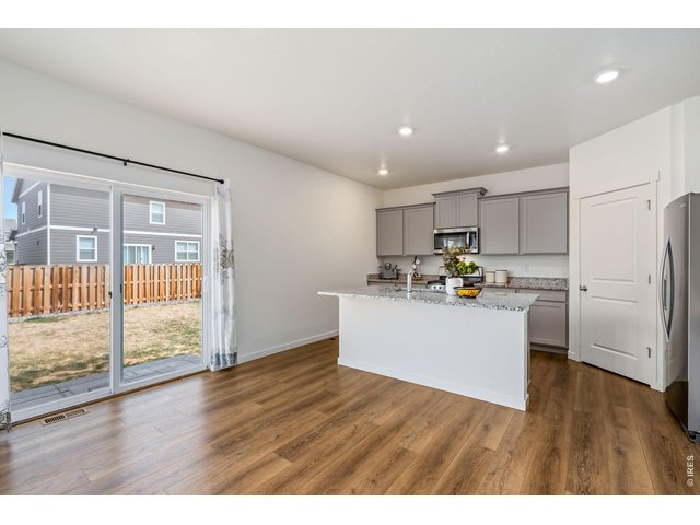 Property Photo 8 The kitchen features a large island, granite countertops, gas range, stainless steel appliances, ample cabinet space, and a spacious pantry.
