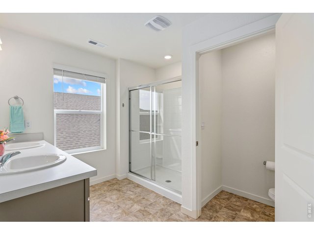 Property Photo 16 Primary bathroom featuring a walk-in shower & double sinks