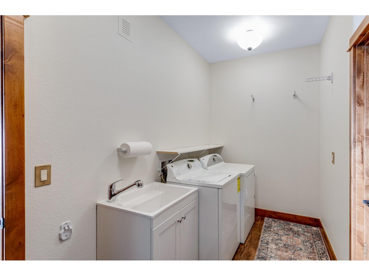 Downstairs laundry room with sink and additional storage
