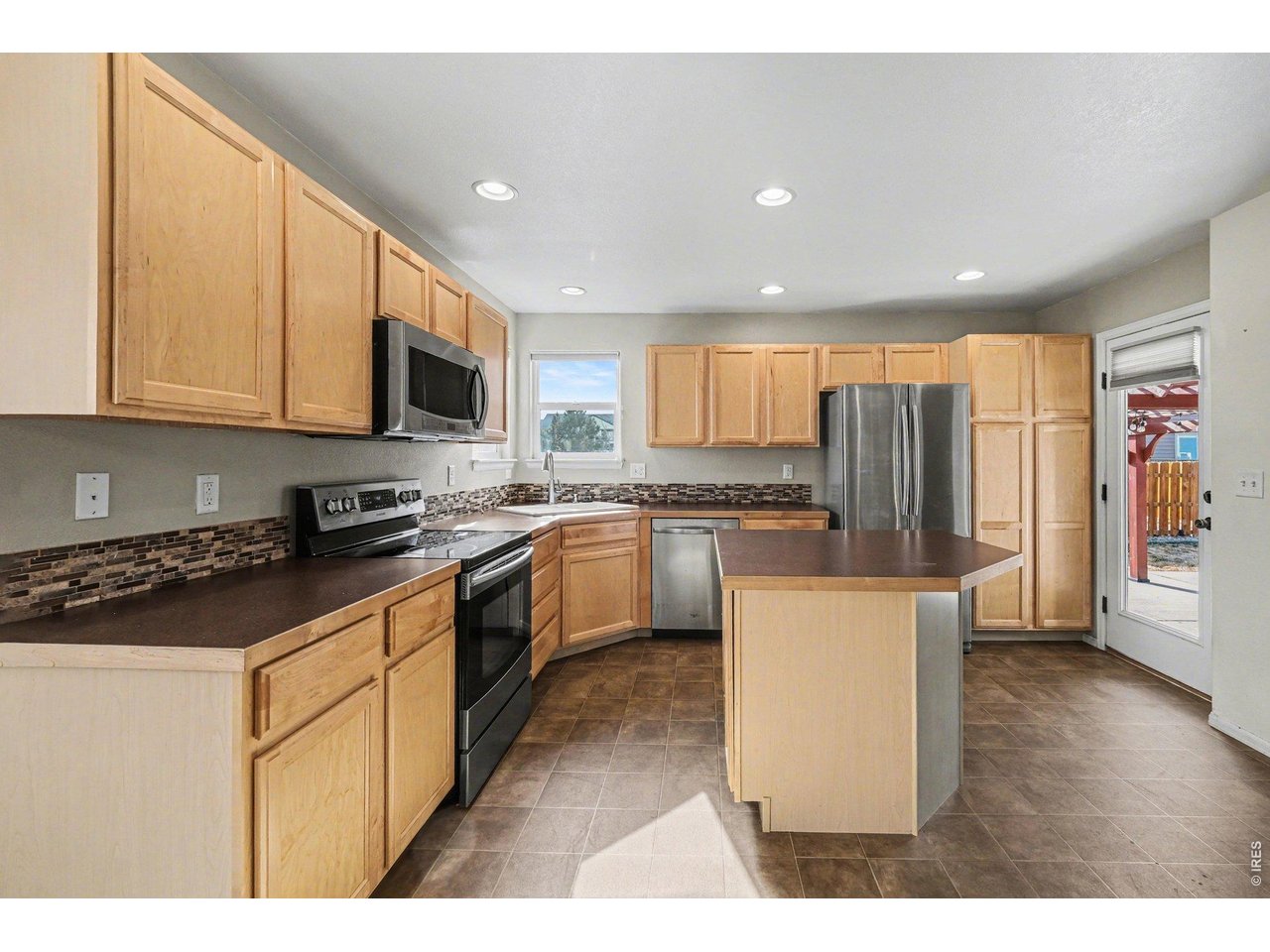 Property Photo 4 Kitchen has a spacious island and beautiful tile backsplash