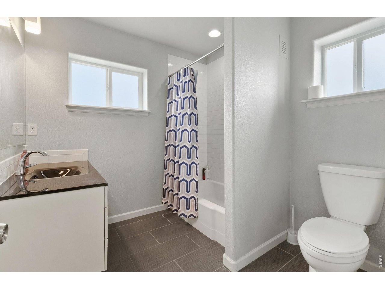 Full bathroom includes a tiled bath, upgraded vanity, and updated finishes. 