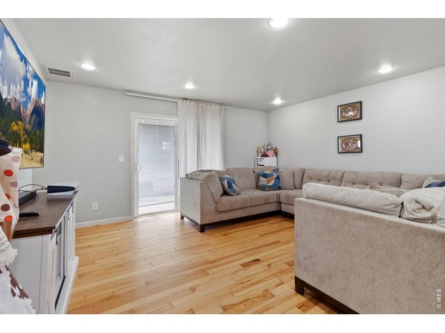 Property Photo 11 Spacious living area with recessed lighting & ample natural light. Updated hardwood flooring throughout the home. 