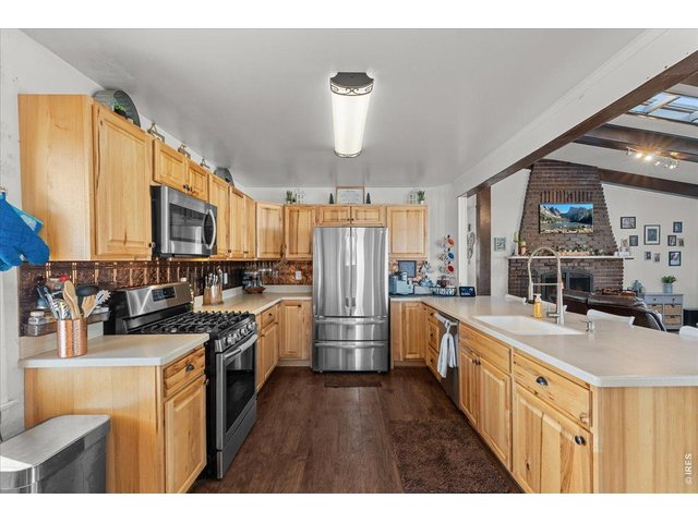 Property Photo 8 Remodeled kitchen with new cabinetry, faux tin backsplash, solid surface countertops and stainless appliances.