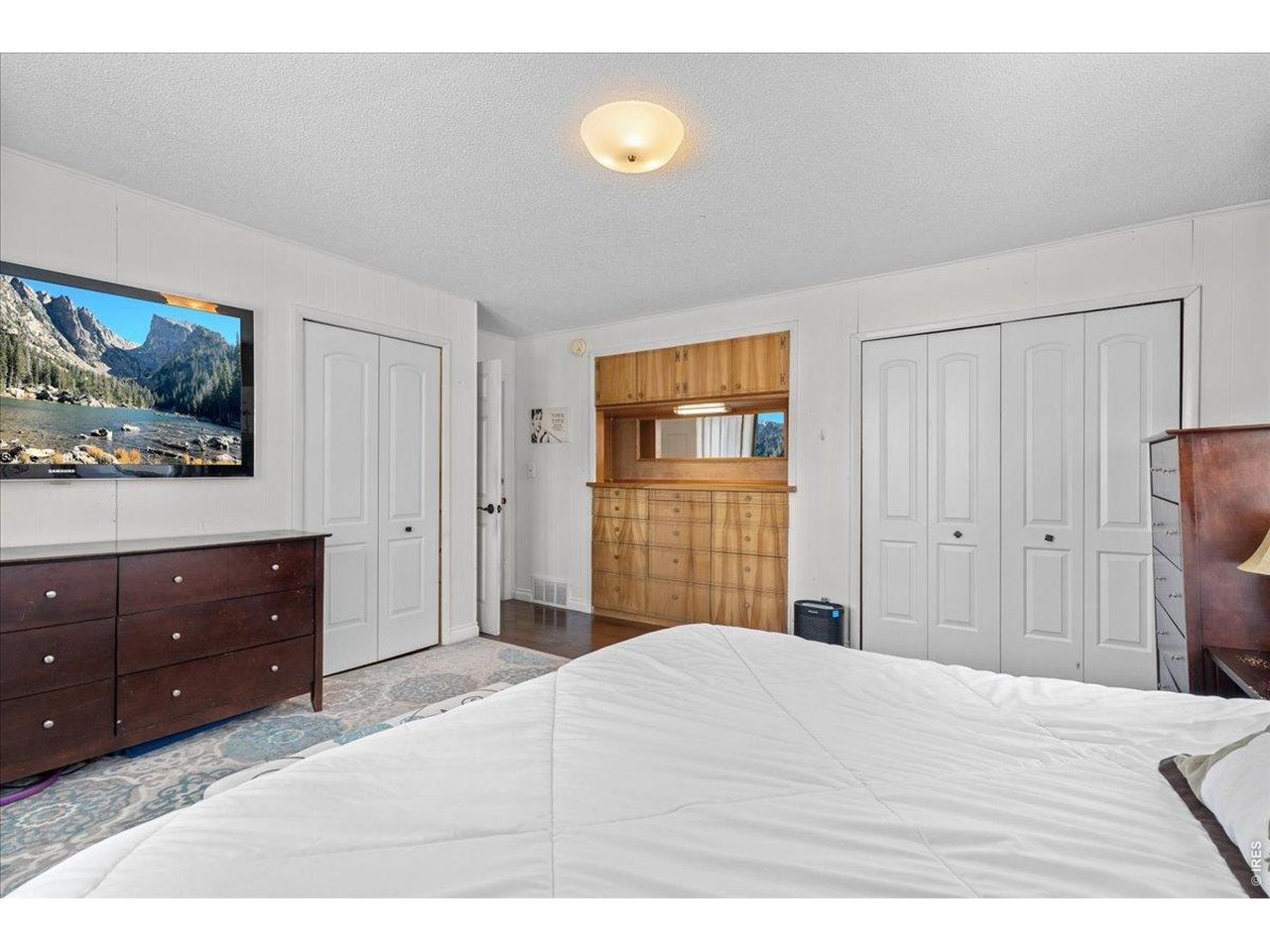 Primary bedroom with built-in dresser, mirror and cabinet plus two closets.