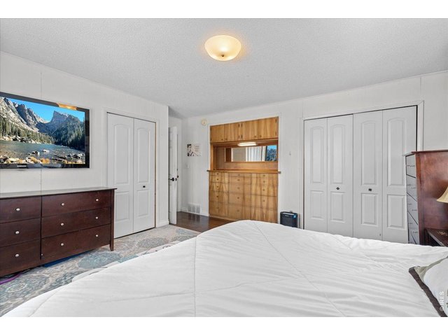 Property Photo 17 Primary bedroom with built-in dresser, mirror and cabinet plus two closets.