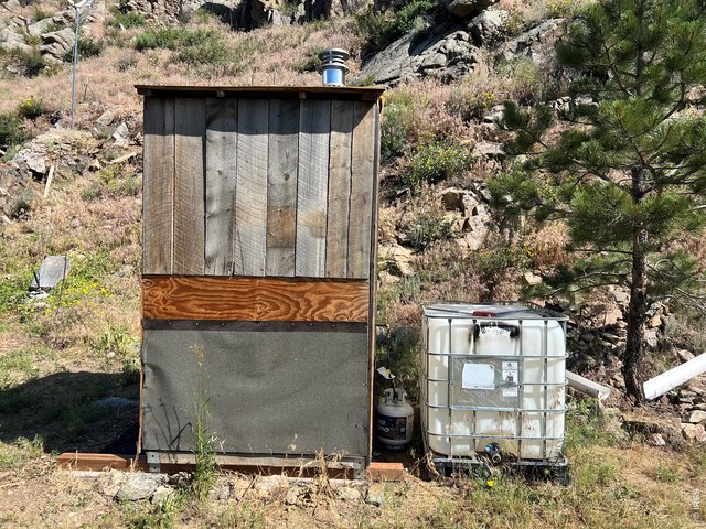 Property Photo 27 Side view of outhouse with one of the two 250-gallon water cisterns