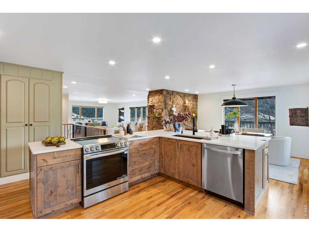 The fully remodeled kitchen features quartz countertops, large center island, breakfast bar, pantry, abundant cabinets, & stainless steel appliances