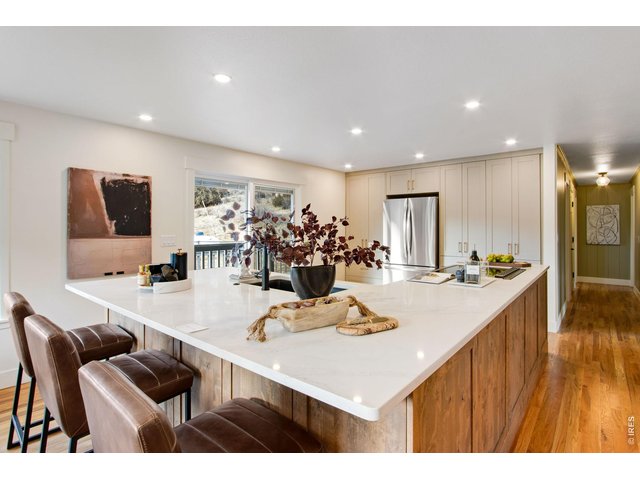 Property Photo 25 The fully remodeled kitchen features quartz countertops, large center island, breakfast bar, pantry, abundant cabinets, & stainless steel appliances.
