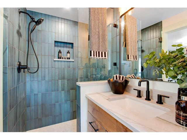 Property Photo 32 Private and completely remodeled bath featuring quartz countertops, tile flooring, shower with floor to ceiling tile backsplash, and a full length walk-in closet.
