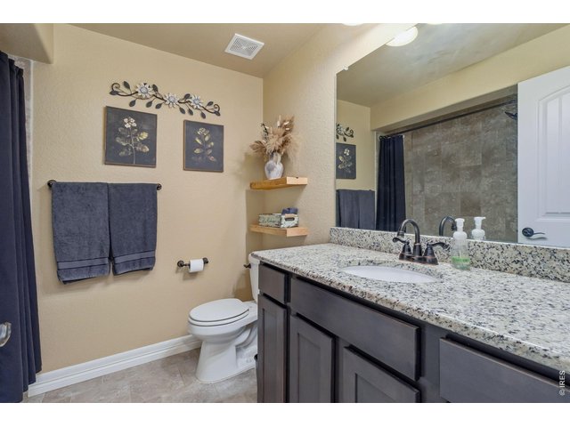 Property Photo 30 This full Bathroom in the basement is conveniently located between bedrooms 4 and 5. Upgraded finishes with tile bath surround and floors, granite countertops and upgraded fixtures.