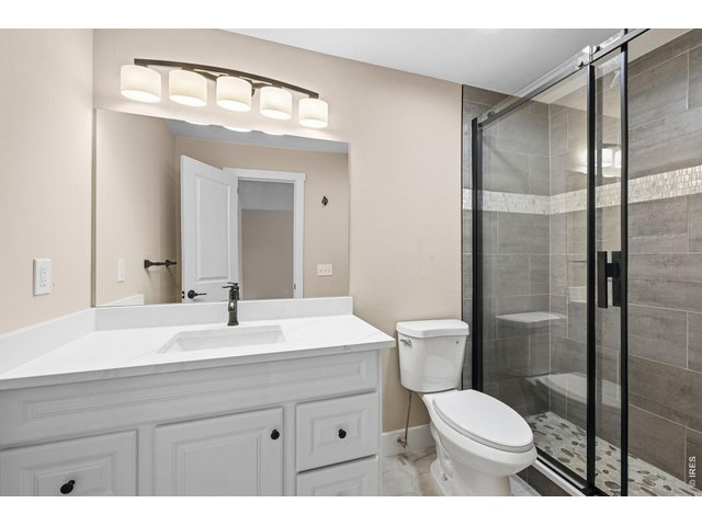 Property Photo 4 2026 renovated bathroom with floor to ceiling tiled custom shower with extra tall barn door style glass doors