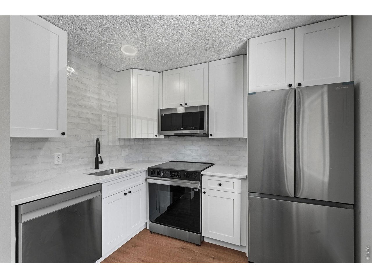 2026 custom kitchen with premium quartz counters, soft close Shaker cabinets, Samsung appliance package with ice maker, and plank flooring