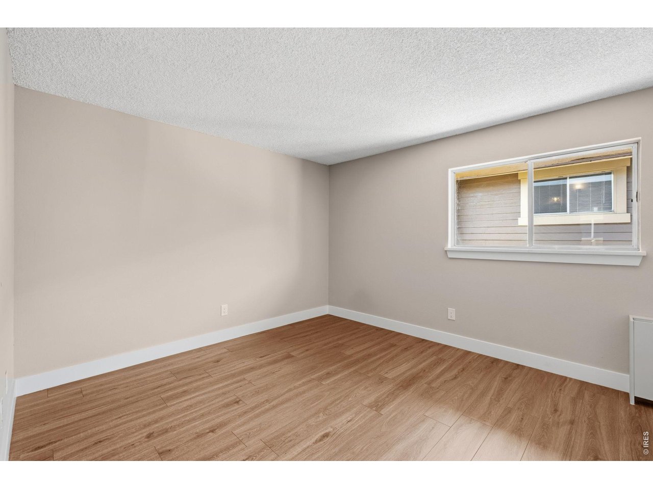 Bedroom with custom paint, plank flooring and oversized window offering views and light