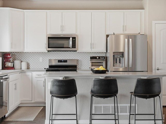 Property Photo 12 White Kitchen Cabinets with Island Seating