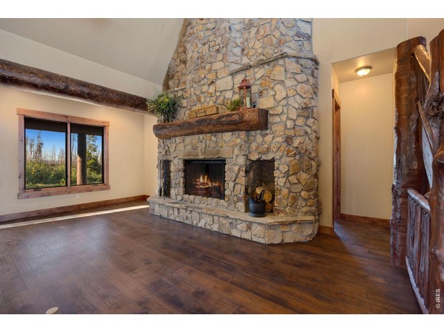 Property Photo 17 Custom floor to ceiling fireplace, surrounded by large windows, complete with logs and stone harvested from the property
