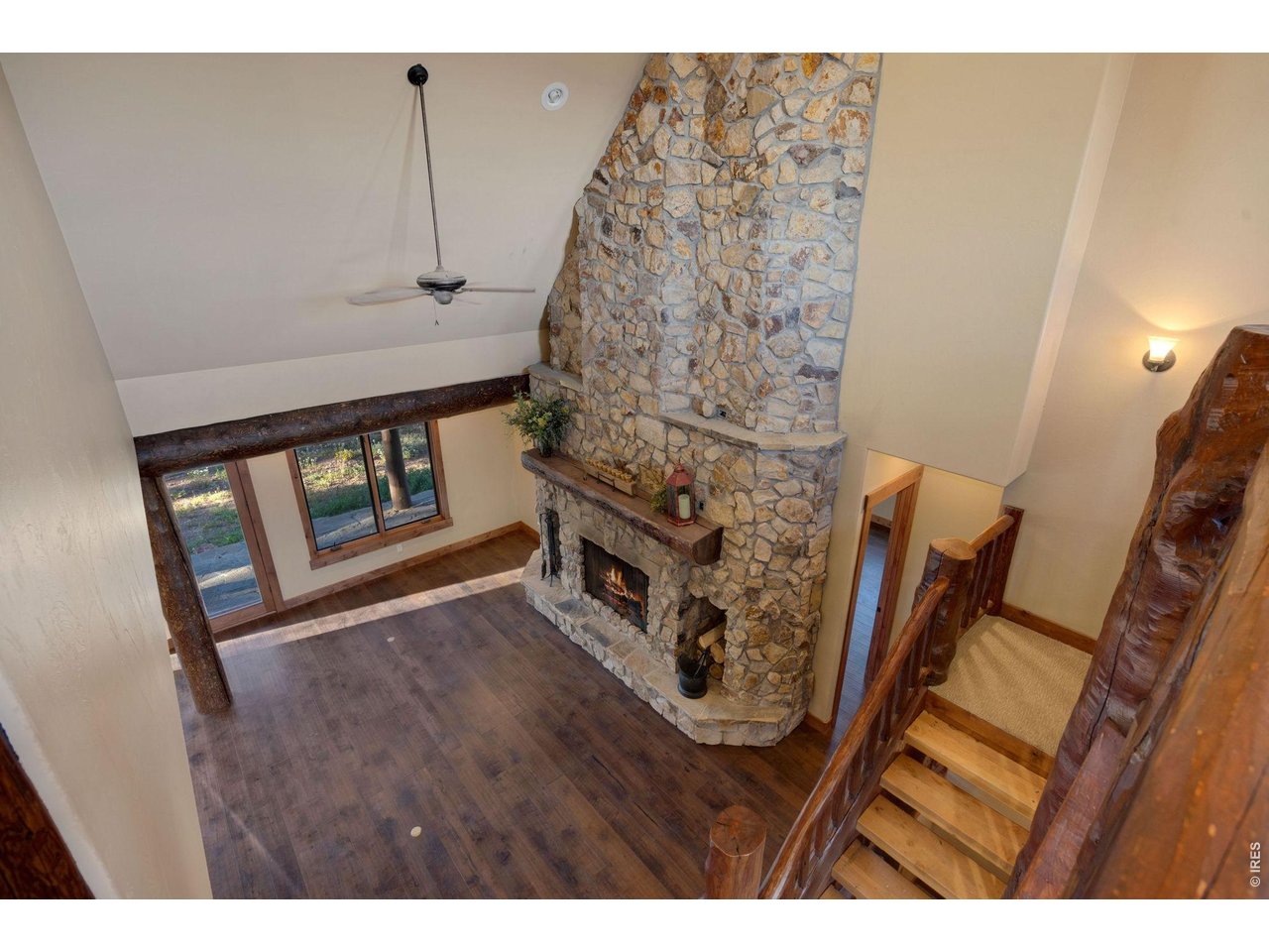 Balcony view of the floor to ceiling fireplace, custom log staircase and high ceilings