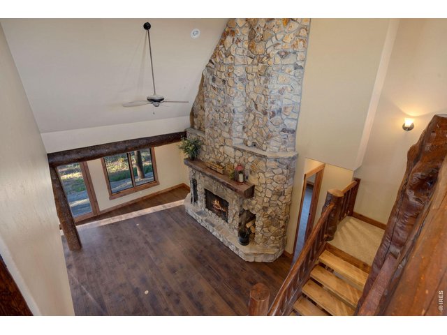 Property Photo 22 Balcony view of the floor to ceiling fireplace, custom log staircase and high ceilings