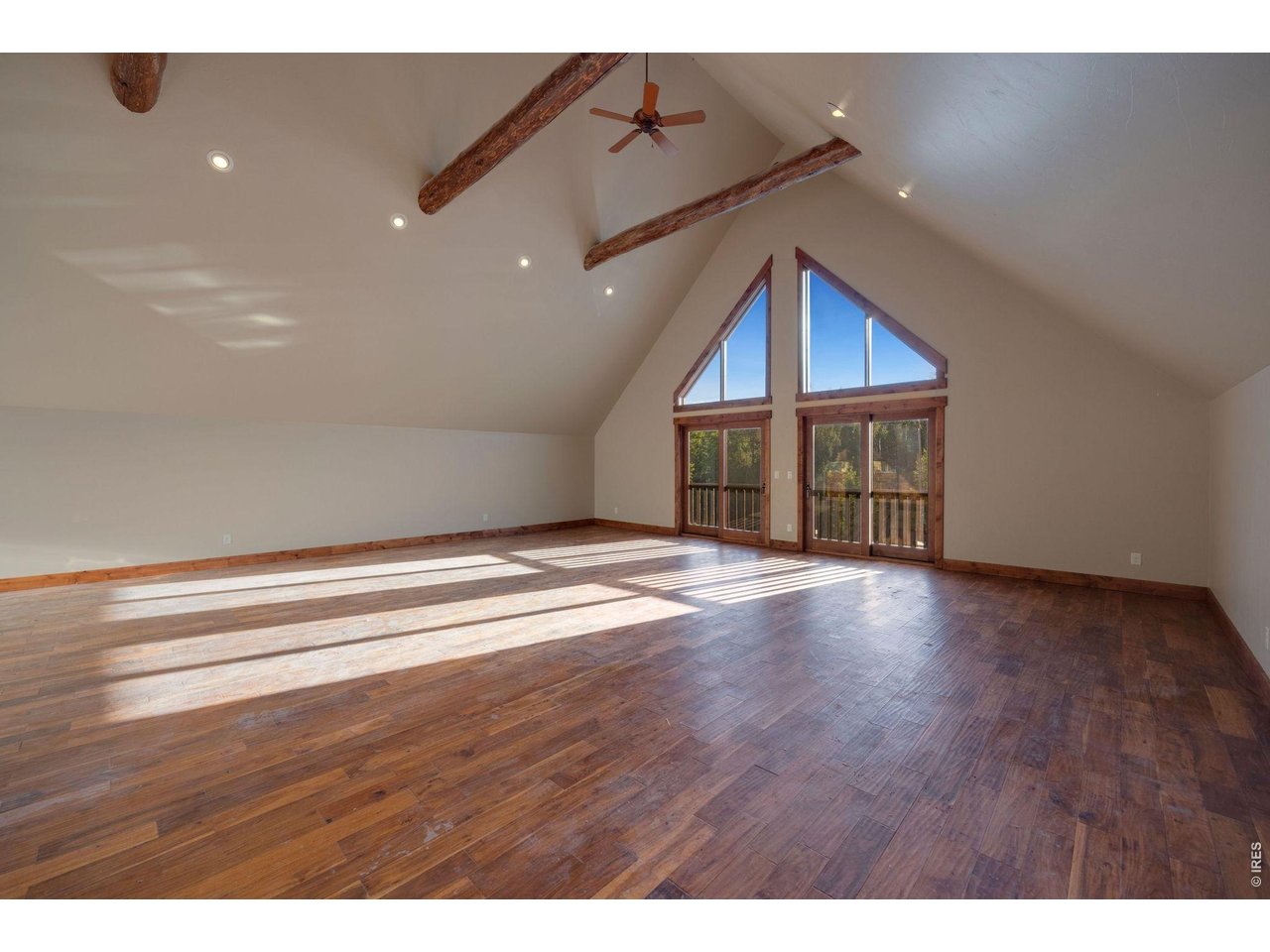  Large greatroom with ceiling fans, sliding glass for natrual air movement and catching the sounds of the outdoors that echo through the large vaulted ceilings, additional wet bar and refrigerator out of view but positioned on the left side of the room