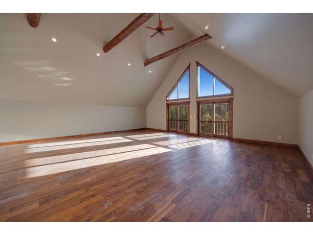 Property Photo 25 Large greatroom with ceiling fans, sliding glass for natrual air movement and catching the sounds of the outdoors that echo through the large vaulted ceilings, additional wet bar and refrigerator out of view but positioned on the left side of the room