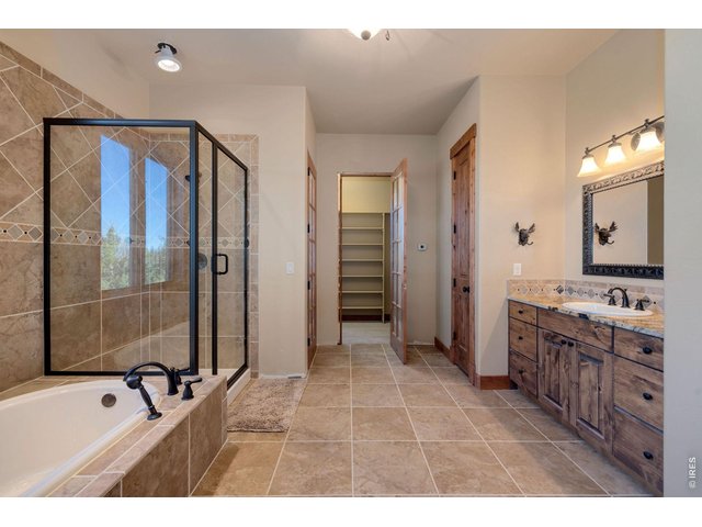 Property Photo 18 Primary bath with large soaking tub, walk-in shower, private toiletries, sink, linen closet, and walk-in closet