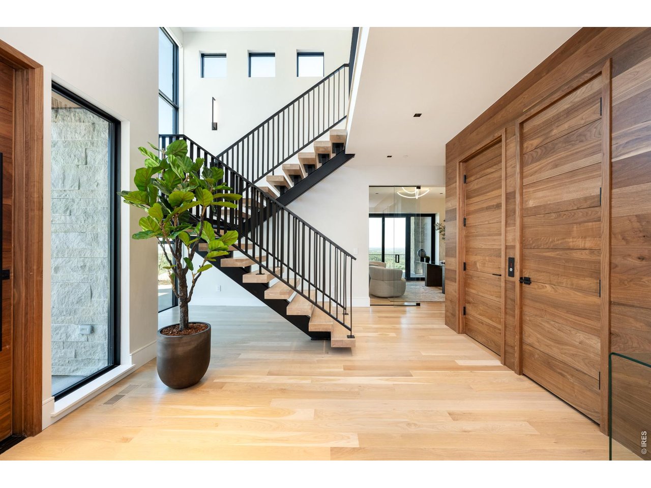 The grand 26-foot foyer features a majestic white oak ceiling and a mono-stair floating staircase with solid white oak treads and immediate access to the garage, symmetry IGD elevator by Morning star and coat closet. 