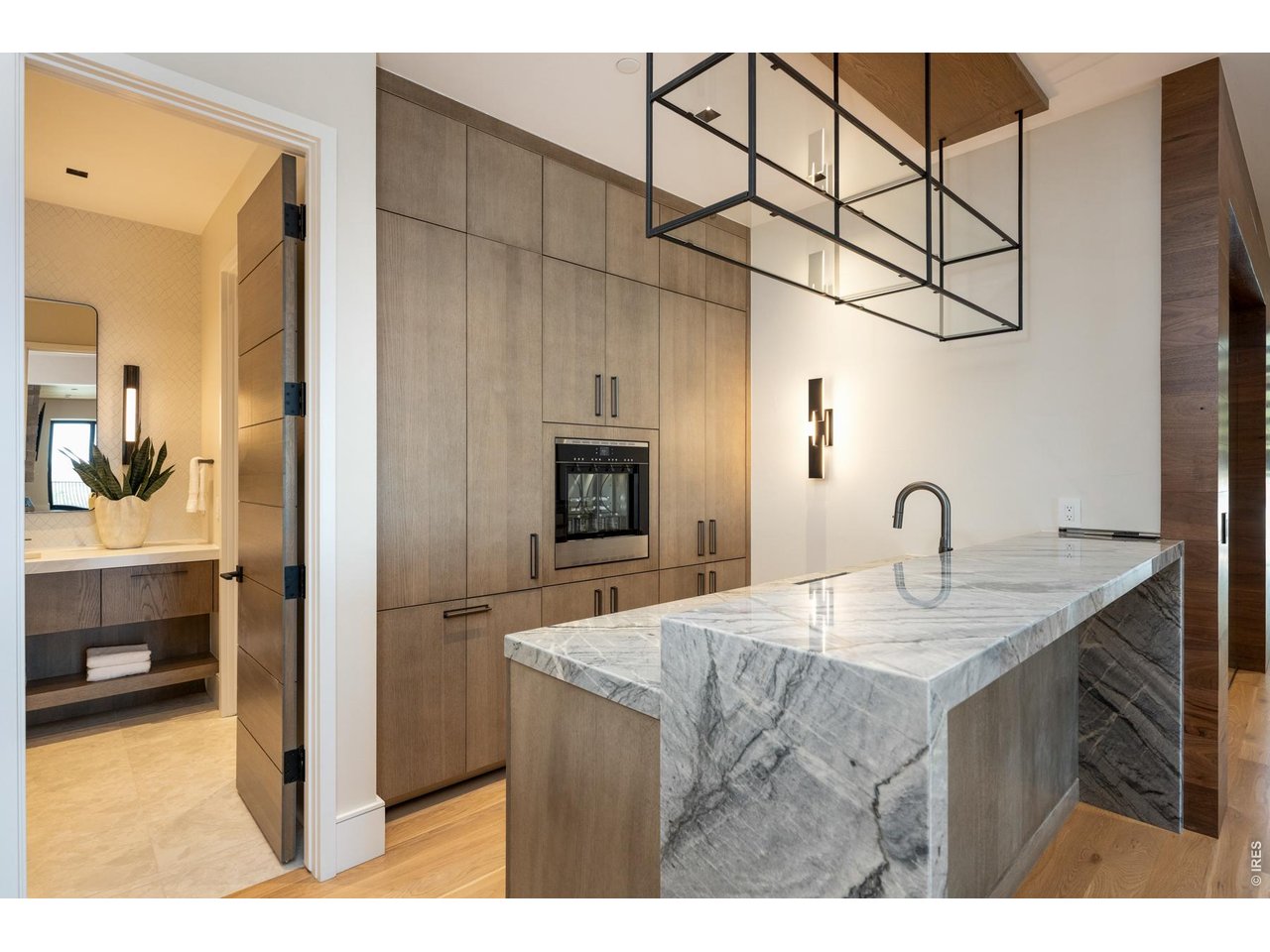 Main level wet bar equipped with a dishwasher, 24" built-in 4 bottle wine dispenser, and 30" built-in bottom freezer, and Iron Abode custom metal shelving. 