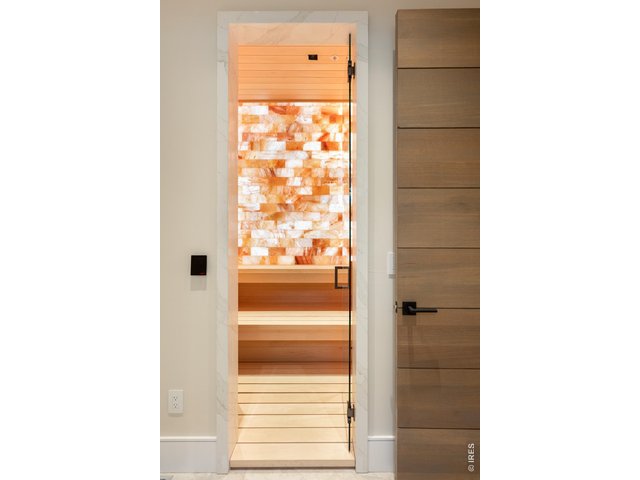 Property Photo 43 The first-floor spa area is connected to the outdoor pool living space and features a Harvia Virta E 240V IOM Sauna with a backlit wall of Himalayan pink salt, steam shower, changing room, water closet, and workout room.