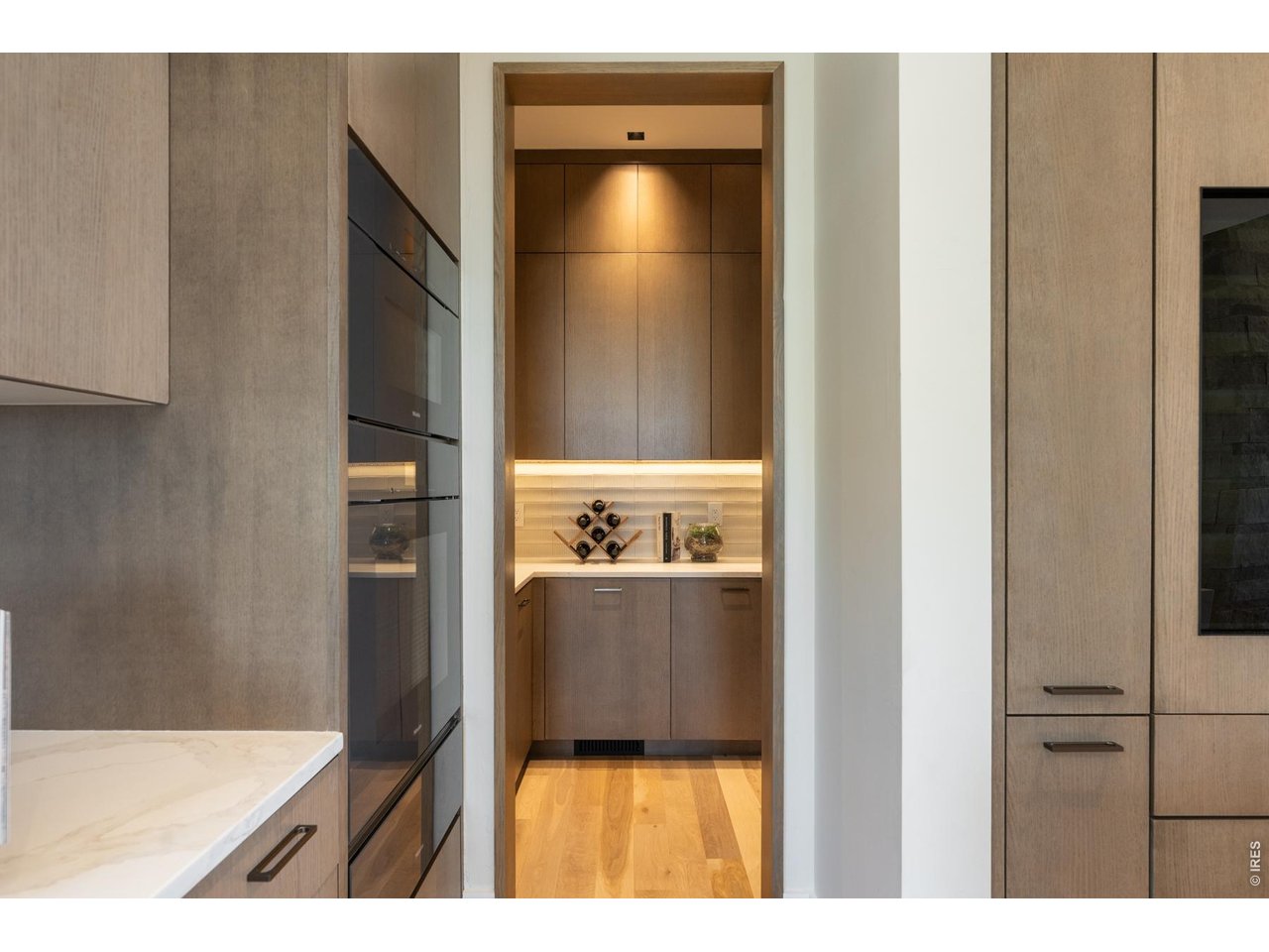 The walk-in scullery features built-in custom cabinetry, additional dishwasher, and built-in plumbed coffee system. 