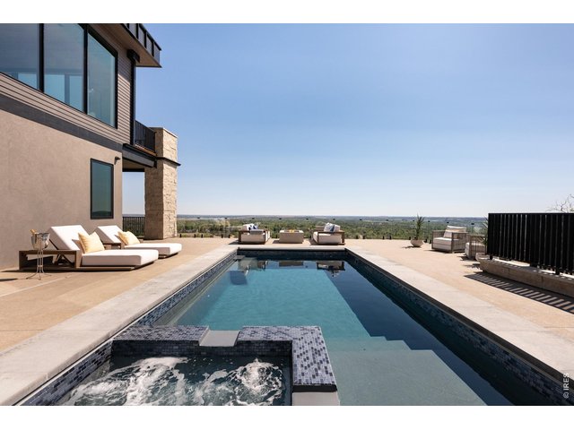 Property Photo 11 A striking 26-ft infinity-edge pool and spa, complemented by a fully equipped outdoor kitchen and 3,650 SF of outdoor living space, creates an unparalleled setting to entertain and unwind. 