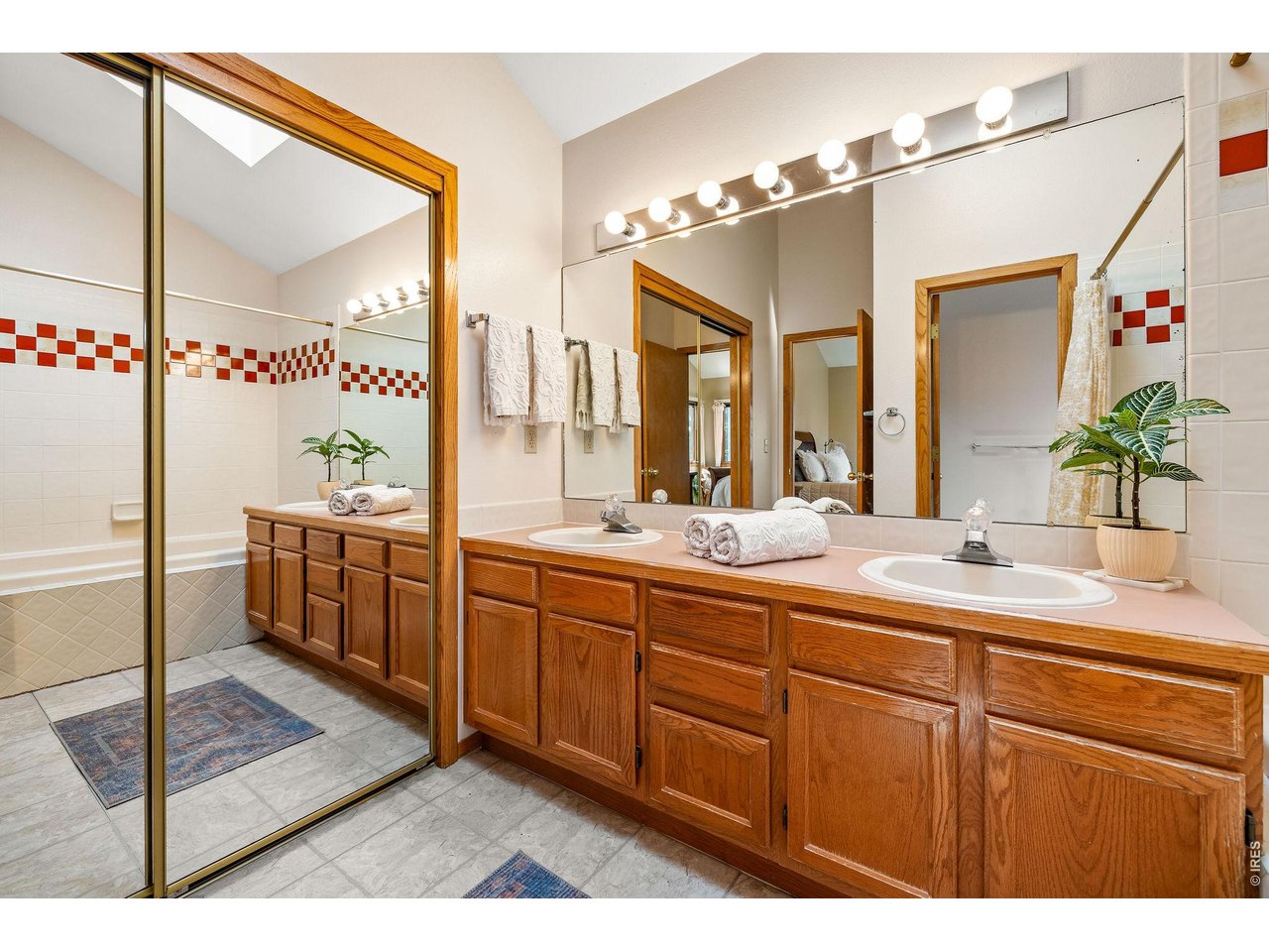 The en suite primary bathroom includes a soaking tub/shower, wide double vanity, private water closet, skylight and massive walk-in closet. 