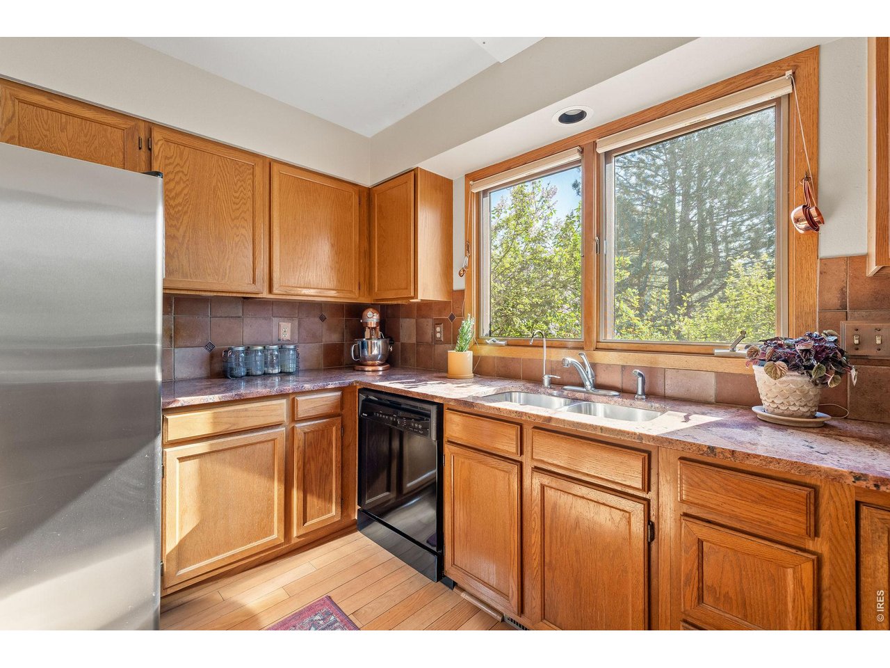 The large eat-in kitchen offers wood cabinetry, granite countertops, full-size appliances and oversized windows framing surrounding nature. 