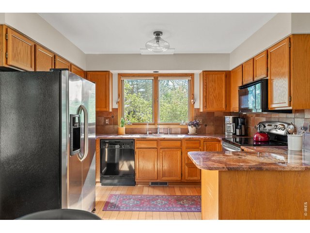 Property Photo 19 Sun-filled kitchen offers plenty of space for storage, making a tidy, organized kitchen a breeze. 
