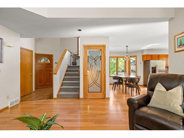 Property Photo 24 A gracious tiled foyer with a powder room and coat closet welcomes you inside the main level, where double-height ceilings soar above hardwood floors and walls of wood-trimmed windows framing leafy, open-sky views. 