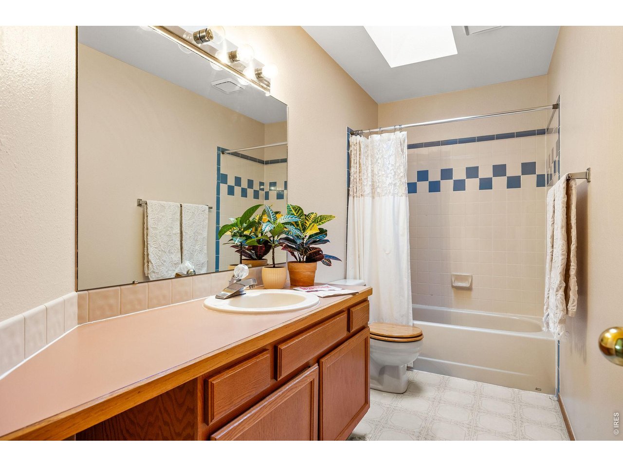 Shared full guest bathroom adjacent to a generous linen closet.
