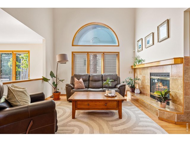 Property Photo 14 A gracious tiled foyer with a powder room and coat closet welcomes you inside the main level, where double-height ceilings soar above hardwood floors and walls of wood-trimmed windows framing leafy, open-sky views. 