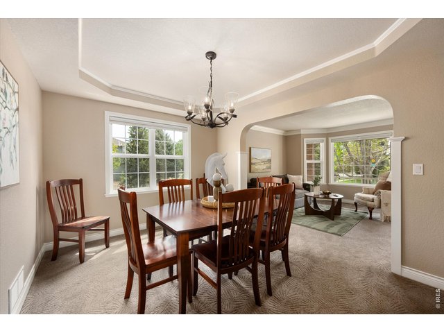 Property Photo 8 Formal Dining Room featuring a tray ceiling and refined finishes 