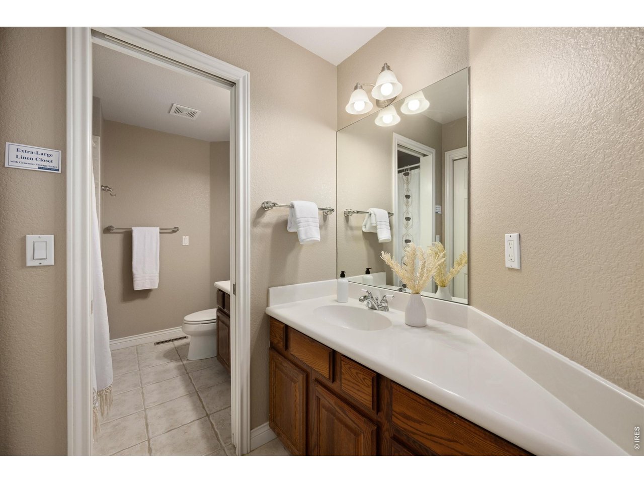 Nicely appointed second bathroom with separate toilet and shower and a convenient double linen closet.