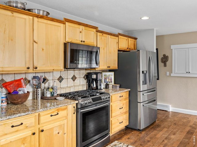 Property Photo 11 The spacious kitchen is a standout with granite countertops, stainless steel appliances, and easy access to the backyard patio-ideal for entertaining or everyday living