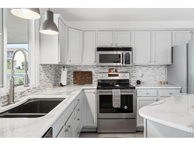 Property Photo 12 Updated kitchen with all appliances included, new countertops, backsplash, and a center island